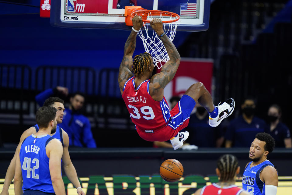 Philadelphia 76ers' Dwight Howard hangs on the rim after a dunk during the first half of an NBA basketball game against the Dallas Mavericks, Thursday, Feb. 25, 2021, in Philadelphia. (AP Photo/Matt Slocum)