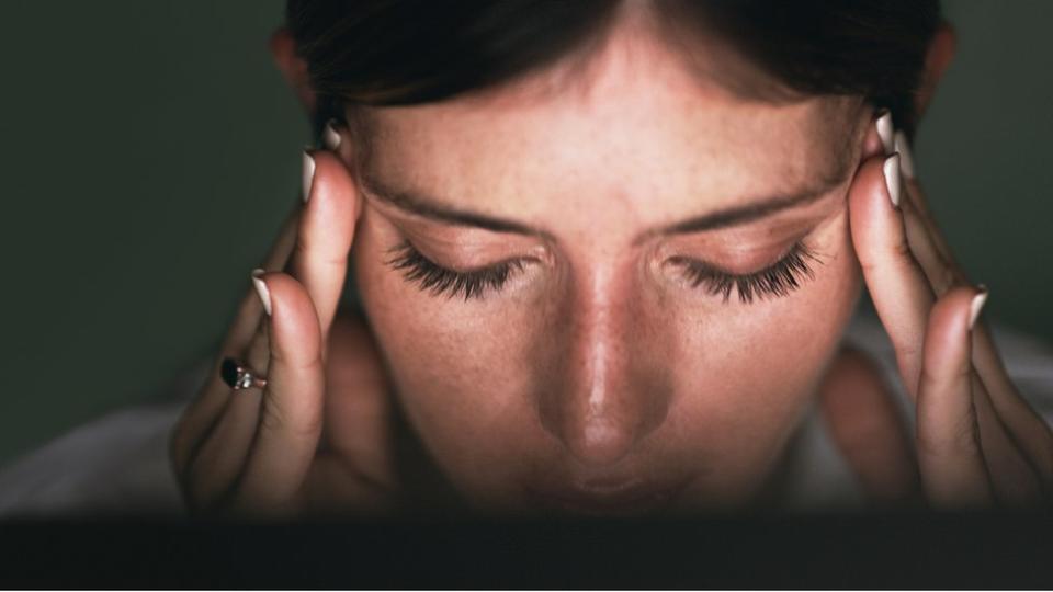 Una mujer padeciendo dolor de cabeza.