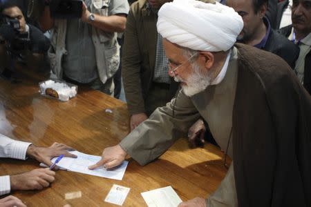 FILE PHOTO: Mehdi Karroubi places his finger print on a ballot paper during the Iranian presidential election in northern Tehran June 12, 2009. REUTERS/Chavosh Homavandi/jamejamonline