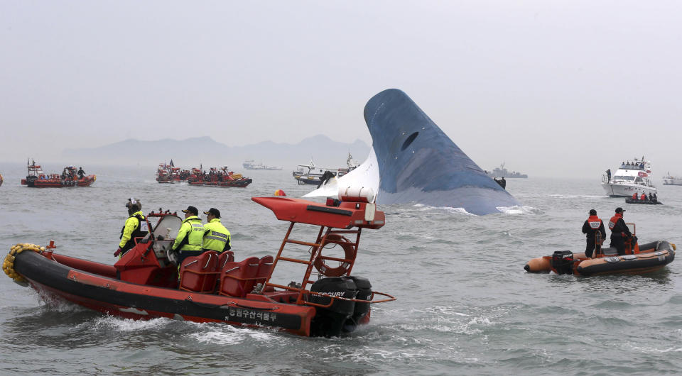 South Korean coast guard officers and rescue team members try to rescue passengers from the ferry Sewol in the water off the southern coast near Jindo, south of Seoul, Wednesday, April 16, 2014. Dozens of boats, helicopters and divers scrambled Wednesday to rescue more than 470 people, including 325 high school students on a school trip, after a ferry sank off South Korea's southern coast. (AP Photo/Yonhap, Hyung Min-woo) KOREA OUT