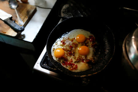 Eggs fry in a pan in Yaneidi Guzman's kitchen in Caracas, Venezuela, March 31, 2018. REUTERS/Carlos Garcia Rawlins