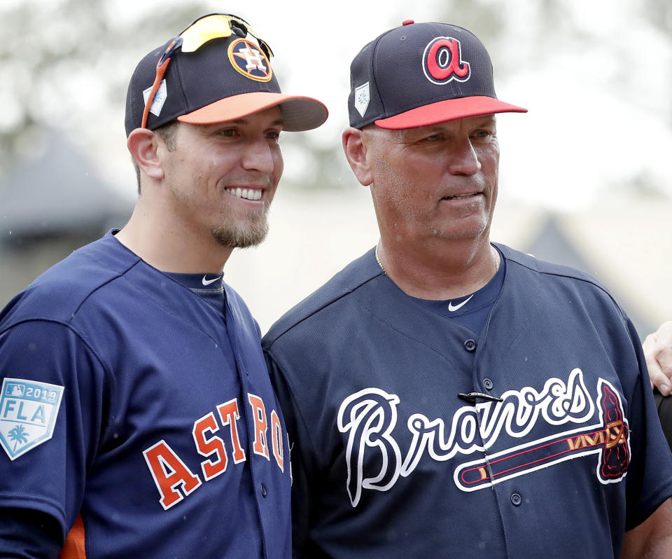 FILE- Houston Astros hitting coach Troy Snitker, left, stands with his father Braves manager Brian Snitker before a spring baseball exhibition game, Monday, March 4, 2019, in Kissimmee, Fla. No matter how this year’s World Series ends, a Snitker will get a championship ring. This edition of the Fall Classic is a family affair with Atlanta Braves manager Brian Snitker in the dugout opposite his son, Houston Astros co-hitting coach Troy Snitker. (AP Photo/John Raoux, File)