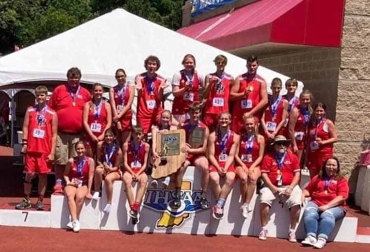 The Bedford North Lawrence Unified Track & Field team displays its 2022 State Championship trophy it garnered Saturday at IU. Coaches Mike and Lori Branam are at lower right.