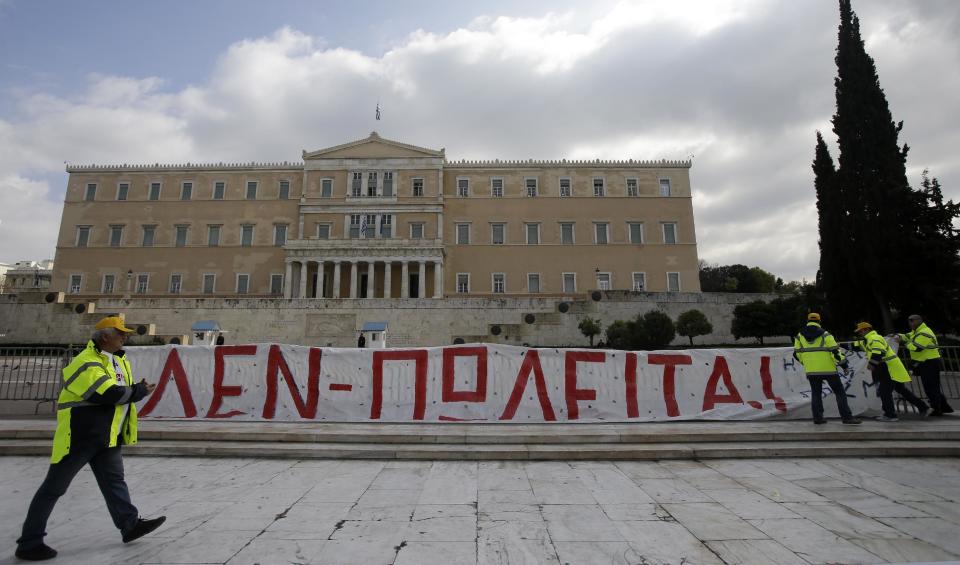 Protesters hang a banner reads ''Not for Sale'' during a rally by hundreds of striking port workers outside the Greek Parliament in Athens, on Wednesday, Feb. 26, 2014. Greek dock workers across the country walked off the job Wednesday in a 24-hour strike to protest plans to sell a stake in the Piraeus Port Authority, the country's largest port. Privatizing state-held assets is a key part of Greece's international bailout agreement. (AP Photo/Thanassis Stavrakis)