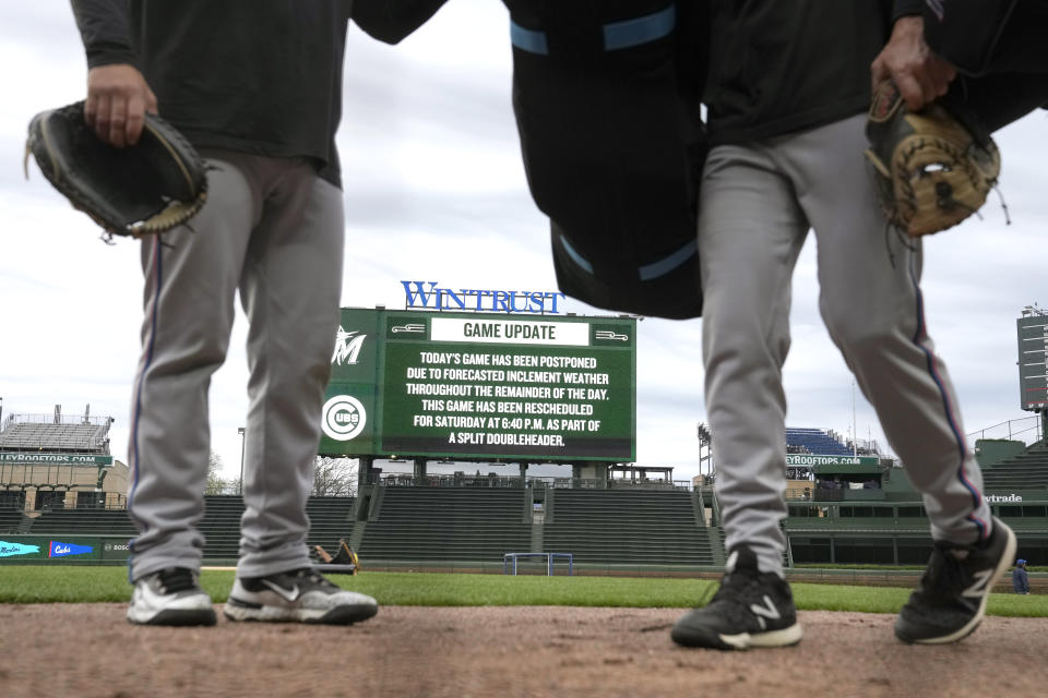 Miami Marlins coaches prepare for batting practice shortly after the baseball game against the Chicago Cubs was postponed Thursday, April 18, 2024, in Chicago. The teams are scheduled to play a split doubleheader Saturday. (AP Photo/Charles Rex Arbogast)