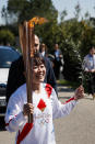Japanese Olympic marathon champion, Mizuki Noguch, the second torchbearer, holds the torch following the flame lighting ceremony at the closed Ancient Olympia site, birthplace of the ancient Olympics in southern Greece, Thursday, March 12, 2020, 2020. Greek Olympic officials are holding a pared-down flame-lighting ceremony for the Tokyo Games due to concerns over the spread of the coronavirus. Both Wednesday's dress rehearsal and Thursday's lighting ceremony are closed to the public, while organizers have slashed the number of officials from the International Olympic Committee and the Tokyo Organizing Committee, as well as journalists at the flame-lighting. (AP Photo/Thanassis Stavrakis)