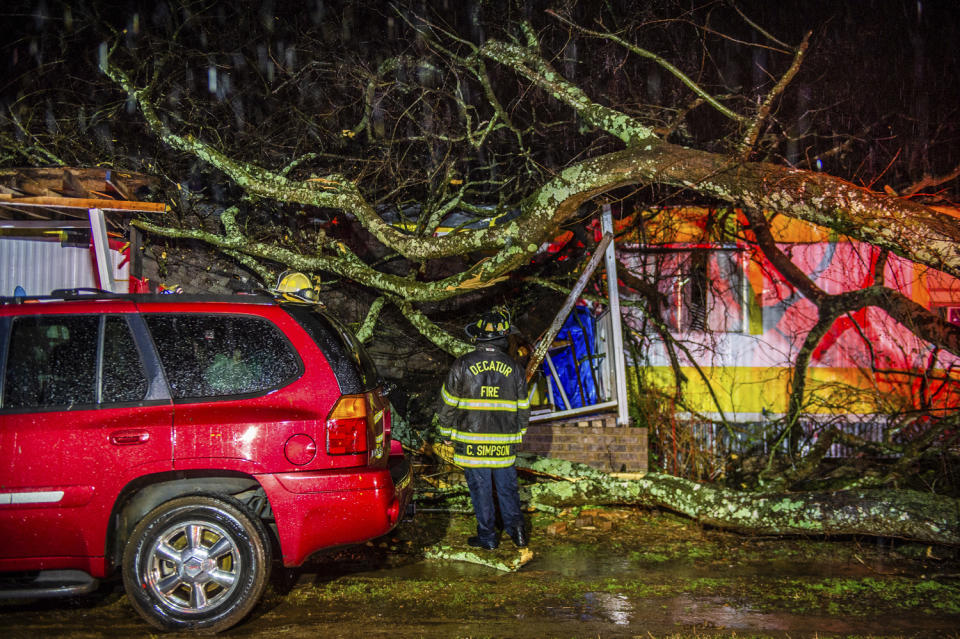 Cory Simpson of Decatur Fire & Rescue assess damage before evacuating a mobile home after a tree fell on the home in Decatur, Ala., Monday, Dec. 16, 2019. Powerful storms smashed buildings, splintered trees and downed power lines Monday around the Deep South, leaving at least one person dead as the dangerous mix of thunderstorms and suspected tornadoes raked the region in the week ahead of Christmas. (Dan Busey/The Decatur Daily via AP)