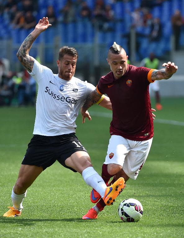 Roma's midfielder Radja Nianggolan (R) vies with Atalanta's forward German Denis on April 19, 2015 at the Olympic stadium in Rome