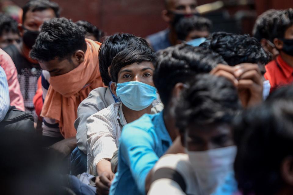 Migrant workers and families gather in front of a police station to get transferred to a railway station to board a special train to Bihar state after the government eased a nationwide lockdown imposed as a preventive measure against the COVID-19 coronavirus, in Chennai on May 27, 2020. (Photo by Arun SANKAR / AFP) (Photo by ARUN SANKAR/AFP via Getty Images)