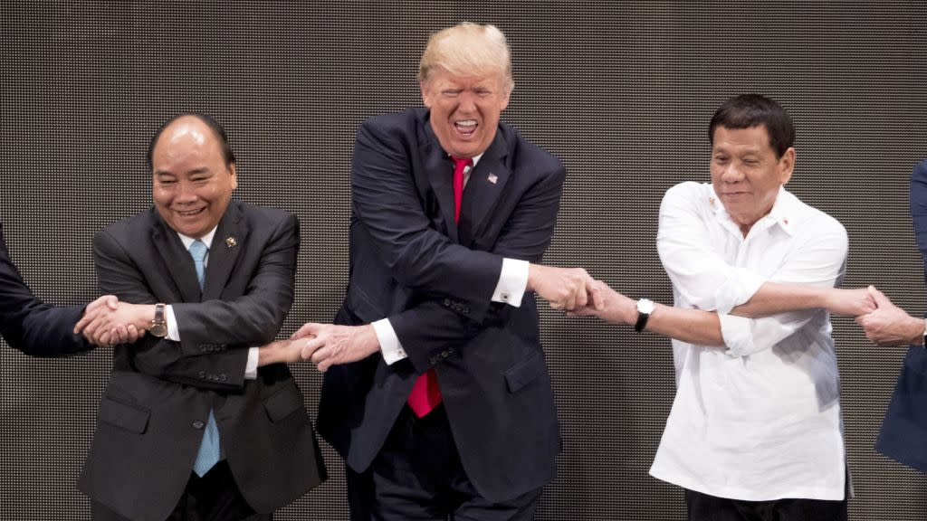 U.S. President Donald Trump, center, reacts as he does the "ASEAN-way handshake" with Vietnamese Prime Minister Nguyen Xuan Phuc, left, and Philippine President Rodrigo Duterte on stage during the opening ceremony at the ASEAN Summit at the Cultural Center of the Philippines, Monday, Nov. 13, 2017, in Manila, Philippines. Trump initially did the handshake incorrectly. Trump is on a five-country trip through Asia traveling to Japan, South Korea, China, Vietnam and the Philippines.
