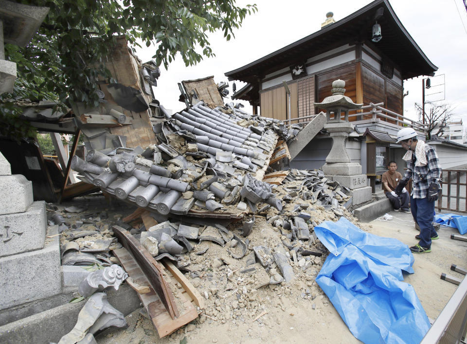 大阪強震造成人命傷亡，各地傳出災情，一寺廟大門倒塌。（圖／美聯社）