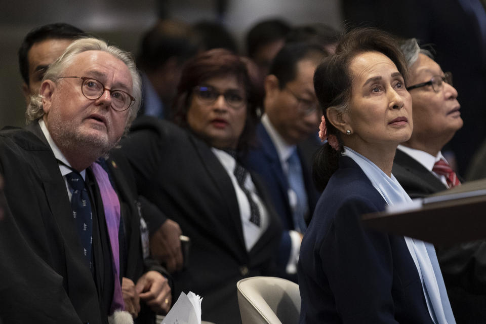 Myanmar's leader Aung San Suu Kyi, right, and legal advisor Prof. William Schabas of Canada, second left, admire the ceiling of the court room prior to addressing judges of the International Court of Justice for the second day of three days of hearings in The Hague, Netherlands, Wednesday, Dec. 11, 2019. Aung San Suu Kyi will represent Myanmar in a case filed by Gambia at the ICJ, the United Nations' highest court, accusing Myanmar of genocide in its campaign against the Rohingya Muslim minority. (AP Photo/Peter Dejong)