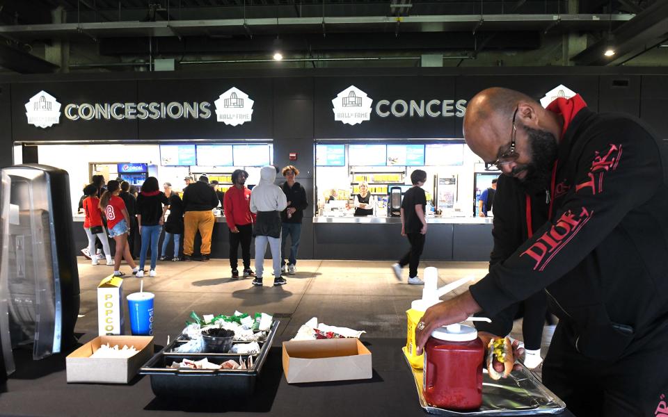 Bo Turner of Canton puts finishing touches on his concession food at Tom Benson Hall of Fame Stadium before the start of a recent Canton McKinley football game.