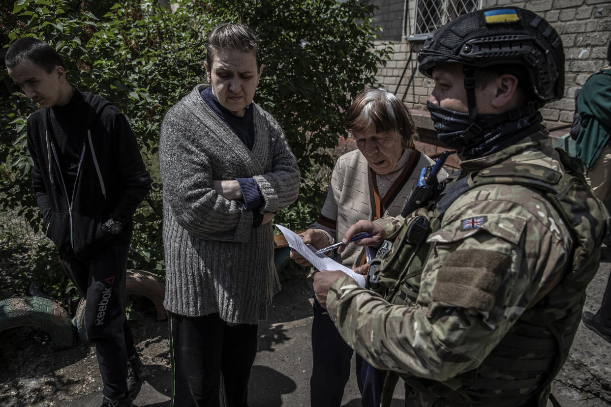 La policía ucraniana auxilia a los residentes de Severodonetsk, Ucrania, el 24 de mayo de 2022. (Finbarr O'Reilly/The New York Times)
