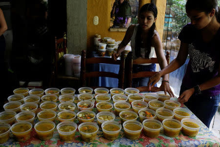 Volunteers of the Make The Difference (Haz La Diferencia) charity initiative serve cups of soup to be donated, at the home kitchen of one of the volunteers in Caracas, Venezuela March 5, 2017. REUTERS/Marco Bello