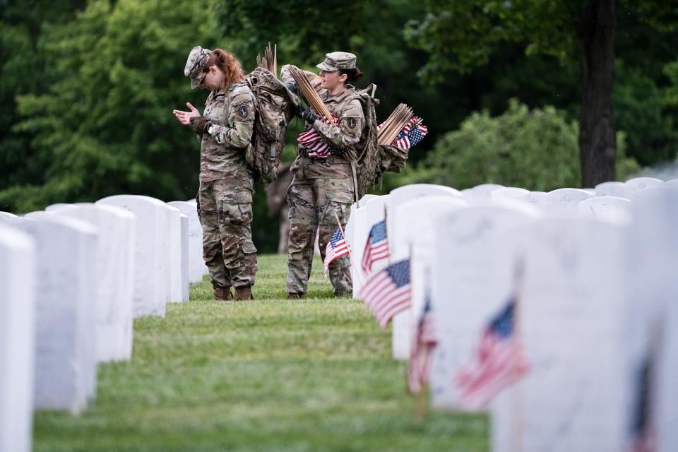 Members of the 3rd U.S. Infantry Regiment prepare to place flags at headstone in a joint service “Flags-In” ceremony at Arlington National Cemetery on Thursday, May 25, 2023.