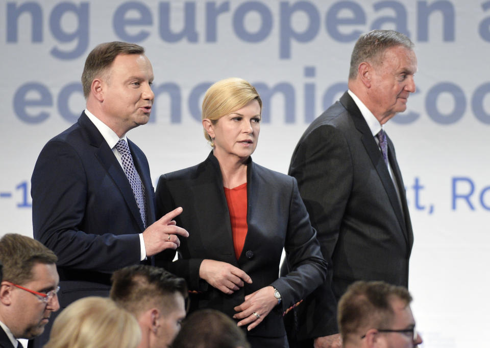 Croatian President Kolinda Grabar-Kitarovic, center, stands next to Polish President Andrzej Duda, left, as James Logan Jones, right, Interim Chairman of the Atlantic Council of the United States walks by, at the Three Seas Initiative Business Forum in Bucharest, Romania, Monday, Sept. 17, 2018. U.S. President Donald Trump has reaffirmed Washington's support for a business summit that aims to boost connectivity in Eastern Europe and improve ties between the region and the U.S.(AP Photo/Andreea Alexandru)