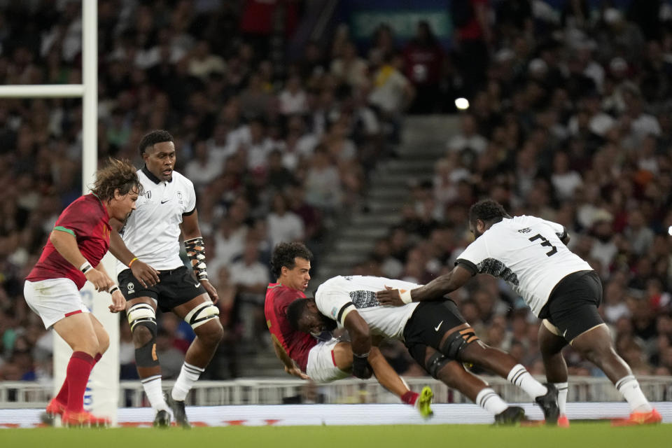 Portugal's Manuel Cardoso Pinto, left, is tackled by Fiji's Temo Mayanavanua during the Rugby World Cup Pool C match between Fiji and Portugal, at the Stadium de Toulouse in Toulouse, France, Sunday, Oct. 8, 2023. (AP Photo/Pavel Golovkin)