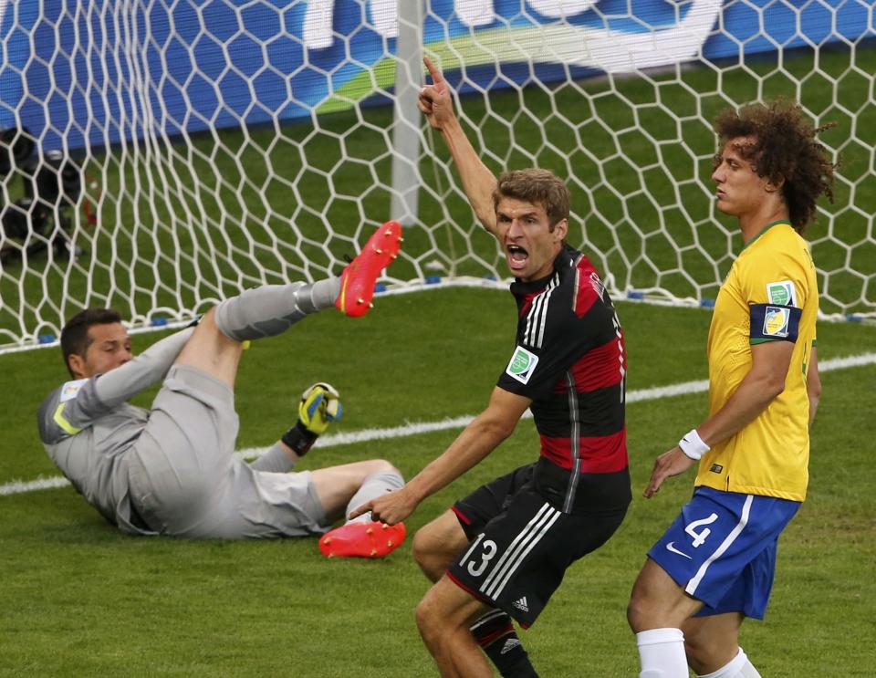 Germany's Thomas Mueller (C) celebrates past Brazil's David Luiz and goalkeeper Julio Cesar after scoring a goal during their 2014 World Cup semi-finals at the Mineirao stadium in Belo Horizonte July 8, 2014. REUTERS/David Gray