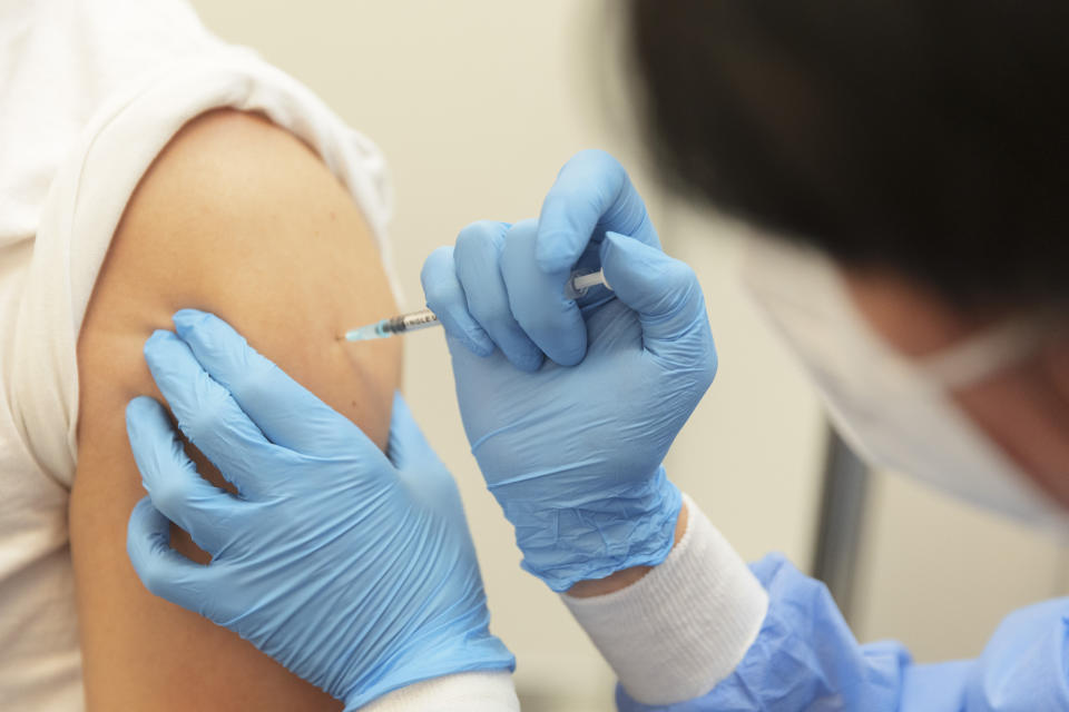 A 24-year-old receives his booster vaccination with the active ingredient Biontech at the new vaccination centre in Bremen, Germany, Friday, Dec. 3, 2021. Numerous booths for the vaccinations against the corona virus are set up in the former cashier's hall in the main branch of the Sparkasse Bremen. In the newly opened vaccination centre, up to 5,000 corona vaccinations per day are planned. (Joerg Sarbach/dpa via AP)