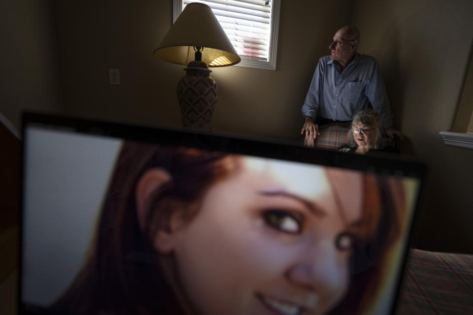 Sandy Phillips and her husband, Lonnie, sit for a portrait at her friend’s home in Lone Tree, Colo., Tuesday, Sept. 5, 2023, behind a photo of her daughter, Jessica Ghawi, who was killed in the 2012 mass shooting at an Aurora, Colo., movie theater. Suffering through their own personal loss after the mass shooting, the couple set out to help other parents like them, traveling to shooting sites around the country. The trip continued for a decade. (AP Photo/David Goldman)