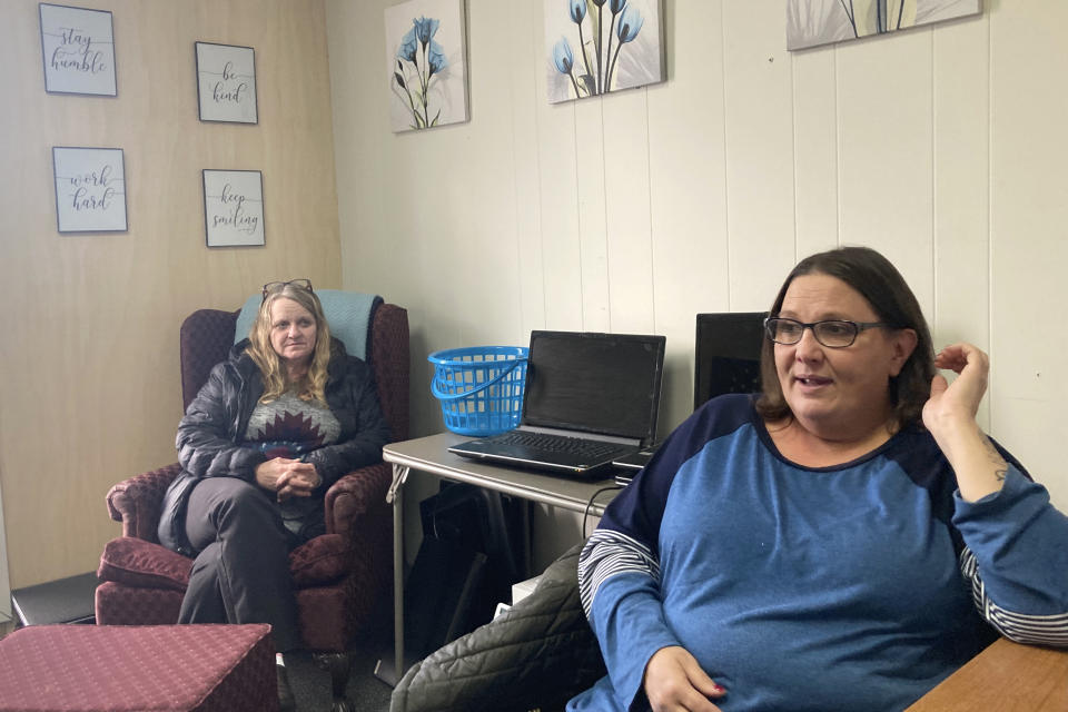 Anne Muilenburg, right, and Debra Cross speak during an interview Thursday, Dec. 9, 2021, in Muilenburg's office in Provoking Hope, a recovery center in McMinnville, Ore., for people addicted to drugs. Muilenburg is the office manager of Provoking Hope and Cross is its director of operations. McMinnville and thousands of other towns across the United States that were wracked by the opioid crisis are on the precipice of receiving billions of dollars in the second-biggest legal settlement in U.S. history. (AP Photo/Andrew Selsky)