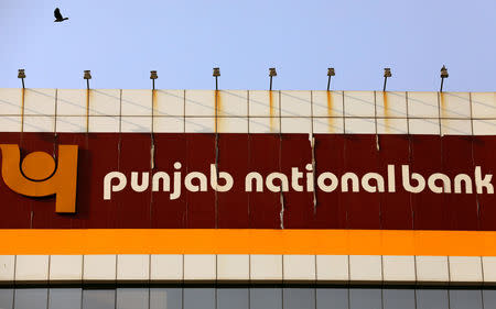 A bird flies past the logo of Punjab National Bank installed on the facade of its office in Mumbai, February 21, 2018. REUTERS/Danish Siddiqui/Files