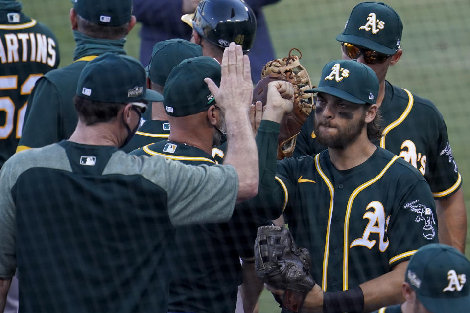 Oakland Athletics' Chad Pinder, right, celebrates with manager Bob Melvin after the Athletics defeated the Houston Astros in Game 3 of a baseball American League Division Series in Los Angeles, Wednesday, Oct. 7, 2020. (AP Photo/Marcio Jose Sanchez)