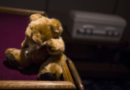 A teddy bear sits on a table next to the casket containing the remains of an abandoned newborn baby in preparation for funeral and burial services at Glueckert Funeral Home in Arlington Heights, Illinois, June 19, 2015. REUTERS/Jim Young