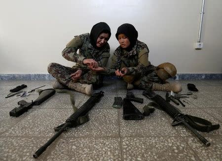 Female soldiers Karima Mohamadi, 21 (L), and Tamana, 19 (R), from the Afghan National Army (ANA) clean their weapons at the Kabul Military Training Centre (KMTC) in Kabul, Afghanistan October 26, 2016. REUTERS/Mohammad Ismail