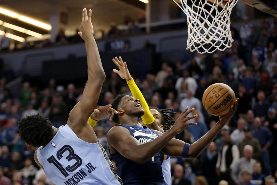 Timberwolves guard Anthony Edwards (1) shoots on Memphis Grizzlies guard Ja Morant, right, and Memphis Grizzlies forward Jaren Jackson Jr. (13) in the fourth quarter of an NBA basketball game Wednesday, Nov. 30, 2022, in Minneapolis. (AP Photo/Andy Clayton-King)