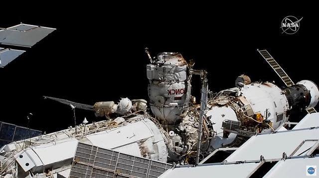 Cosmonauts Sergey Ryzhikov and Sergey Kud-Sverchkov move along the top of the Russian Zarya module, just to the left of the Poisk airlock compartment (extending upward) carrying a replacement pump module. The spacewalk November 18, 2020 is the first ever carried out from Poisk as the Russians prepare to remove and discard the nearly identical Pirs module on the opposite side of the station to make way for a new laboratory.  / Credit: NASA