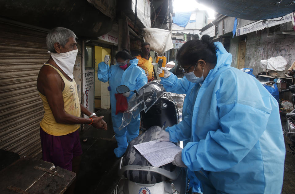 Community health workers screen a man for COVID-19 symptoms in Dharavi, one of Asia's biggest slums, in Mumbai, India, Saturday, Aug. 15, 2020. India's coronavirus death toll overtook Britain's to become the fourth-highest in the world with another single-day record increase in cases Friday. (AP Photo/Rafiq Maqbool)