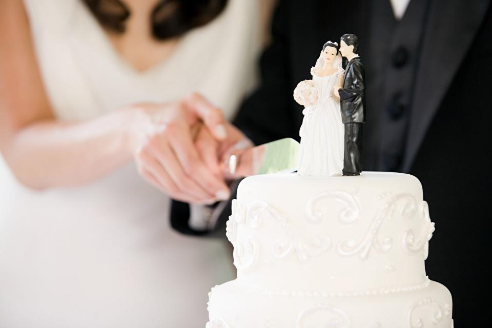 <p>Getty</p> A stock image of a couple cutting a wedding cake