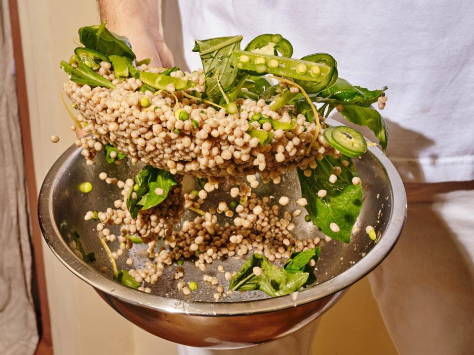 tossing grain salad with vegetables