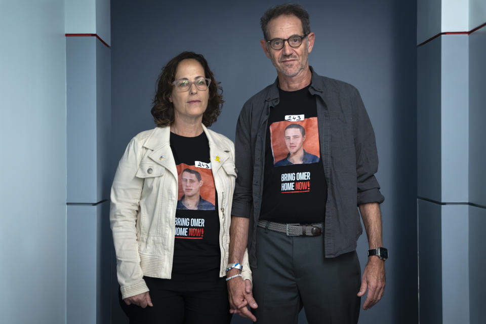 Orna Neutra, left, and her husband Ronen Neutra, of Long Island, N.Y., whose son Omer Neutra, 22, is being held hostage by Hamas in Gaza, hold hands while posing for a portrait, after families of Americans being held hostage in Gaza by Hamas were interviewed, Wednesday, June 5, 2024, by the Associated Press in Washington. The couple wears tape with the number of days that their son has been hostage. (AP Photo/Jacquelyn Martin)