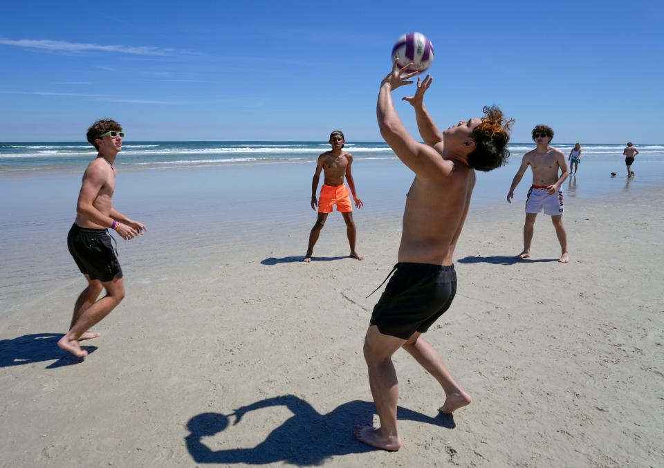 High school spring breakers from Orlando play a game of spike ball at New Smyrna Beach, Wednesday, March 20, 2024.