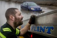 <p>Jeremy Beagle of Burton City Towing watches the cable as he tows a vehicle that was stuck on Robert T. Longway Boulevard on Tuesday, Feb. 20, 2018, in Flint, Mich. High water closed roads in Michigan. (Photo: Bronte Wittpenn/The Flint Journal-MLive.com via AP) </p>