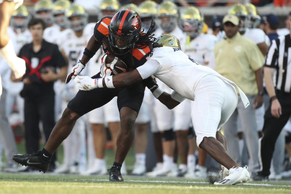 Oregon State running back Deshaun Fenwick, left, is brought down by UC Davis defensive back Markeece Alexander during the first half of an NCAA college football game Saturday, Sept. 9, 2023, in Corvallis, Ore. (AP Photo/Amanda Loman)