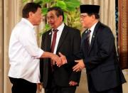 Philippine President Rodrigo Duterte (L) greets Moro Islamic Liberation Front (MILF) chairperson Al Haj Murad Ebrahim (R), while Mohagher Iqbal, MILF peace panel chairman looks on during a handover of a draft law of the Bangsamoro Basic Law (BBL) in a ceremony at the Malacanang presidential palace in metro Manila, Philippines July 17, 2017. REUTERS/Romeo Ranoco