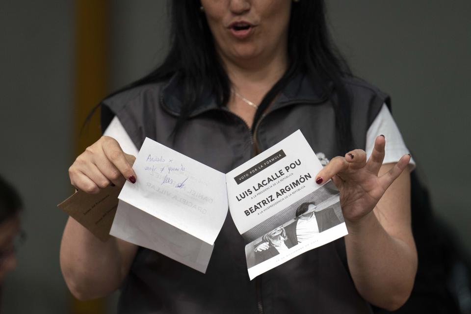 Un voto anulado es mostrado por una oficial electoral uruguaya durante un segundo escrutinio de votos anulados y observados tras el balotaje presidencial en Montevideo, Uruguay, el martes 26 de noviembre de 2019. (AP Foto/Matilde Campodonico)