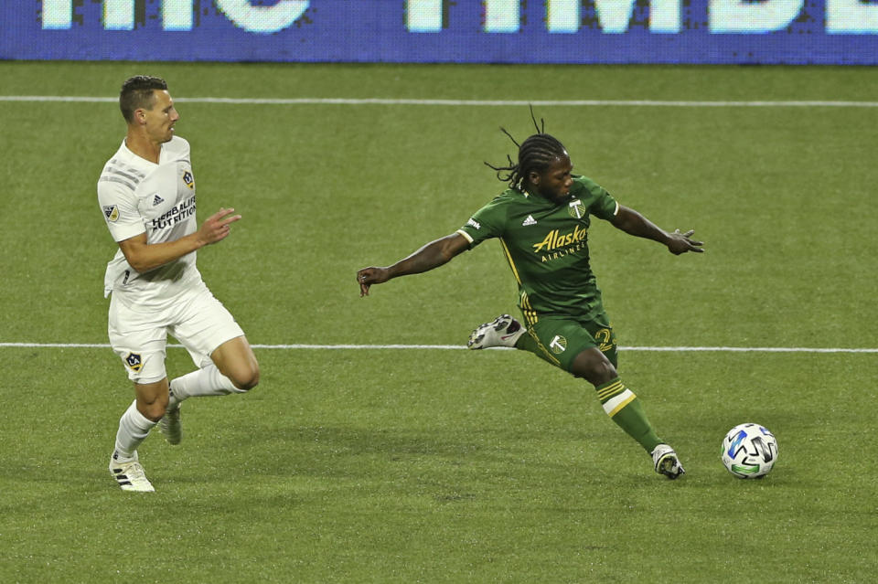 Portland Timbers' Yimmi Chara shoots on goal next to an LA Galaxy player during the first half of an MLS soccer match Wednesday, Oct. 28, 2020, in Portland, Ore. (Sean Meagher/The Oregonian via AP)