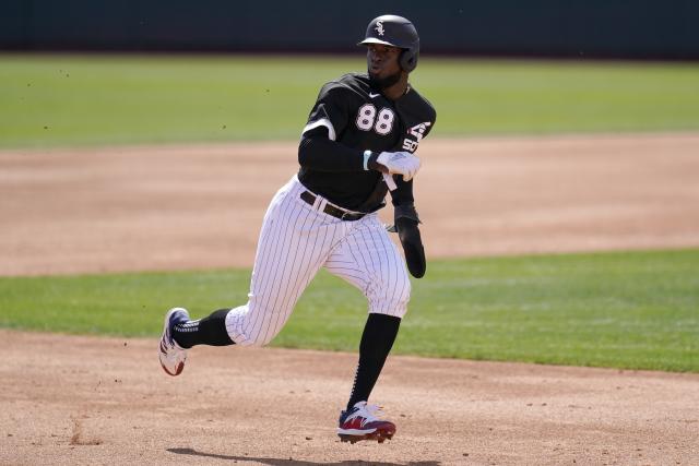 Chicago White Sox's Luis Robert passes third base coach Joe