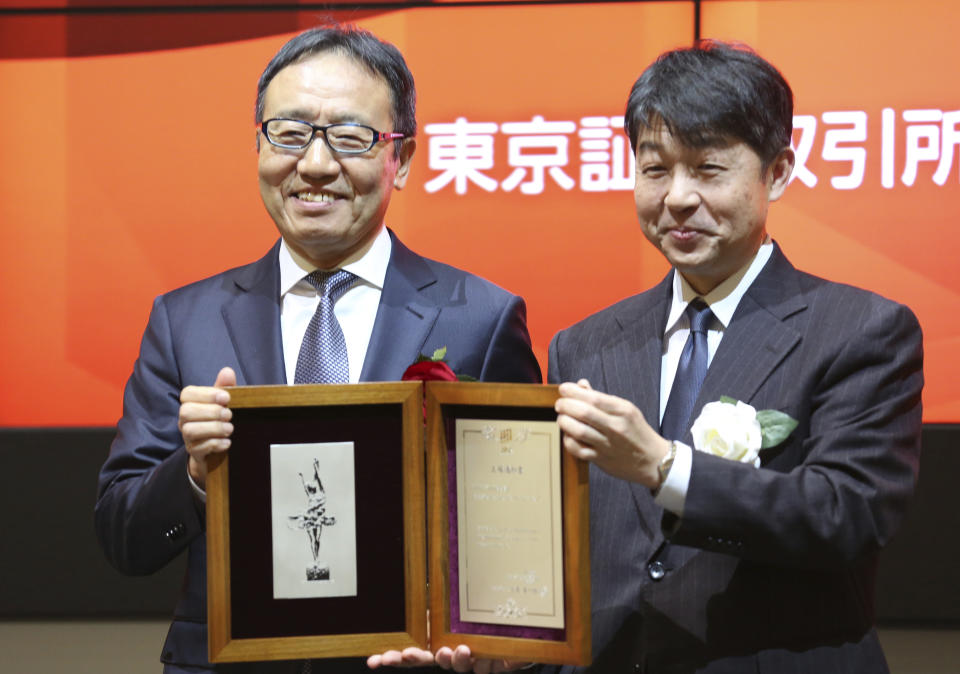 CORRECTS NAME OF KONUMA - SoftBank Corp.'s CEO Ken Miyauchi, left, poses with Yasuyuki Konuma, director and executive officer of Tokyo Stock Exchange during a ceremony at the Tokyo Stock Exchange in Tokyo, Wednesday, Dec. 19, 2018. SoftBank Group Corp.'s Japanese mobile subsidiary began trading on the Tokyo Stock Exchange on Wednesday in one of the world's biggest share offerings. (AP Photo/Koji Sasahara)