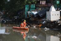 National Disaster Response Force personnel inspect on a dinghy the area where some shanty houses collapsed into a canal due to heavy rains in New Delhi on July 19, 2020. (Photo by Sajjad HUSSAIN / AFP) (Photo by SAJJAD HUSSAIN/AFP via Getty Images)