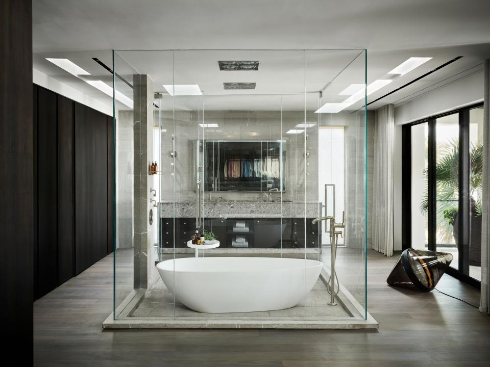 Joyner wanted his master bathroom to be able to take full advantage of its unparalleled ocean views. The RiFRA tub sits in the middle of the room, and two separate Waterworks shower heads are installed in the ceiling: one for taking a shower in the bathtub and one that is separate. A nearby floor lamp by Dan Yeffet is the perfect accompaniment for nighttime soaks. Part of Joyner’s large closet can be seen in the reflection of the mirror over the sinks.