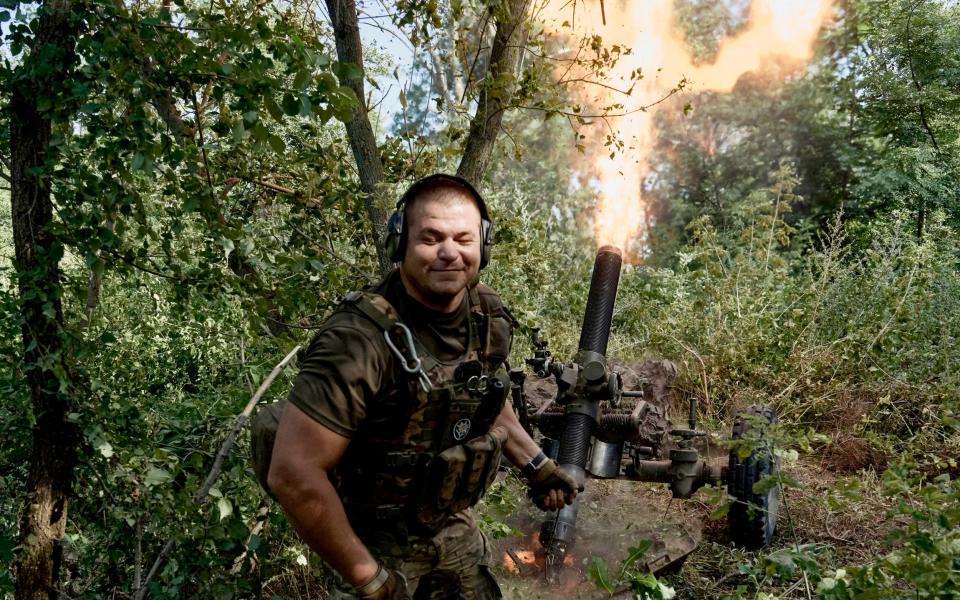 A Ukrainian serviceman of the 10th Assault Brigade Edelweiss fires a 122mm mortar towards Russian positions at the front line, near Bakhmut