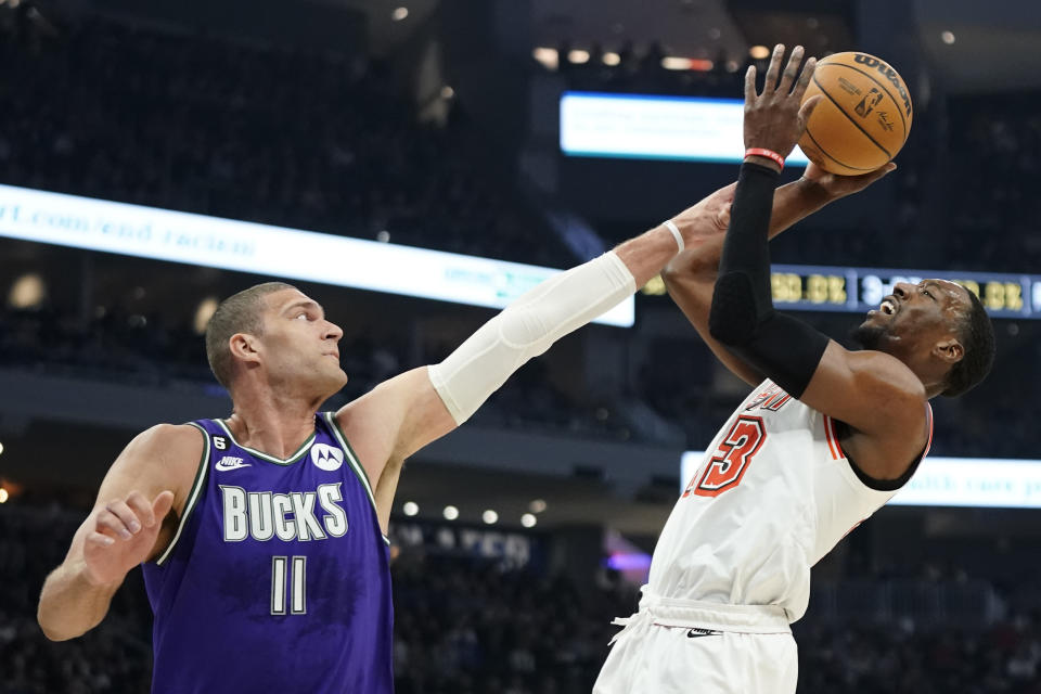 Miami Heat's Bam Adebayo, right, attempts a shot against Milwaukee Bucks' Brook Lopez during the first half of an NBA basketball game Friday, Feb. 24, 2023, in Milwaukee. (AP Photo/Aaron Gash)