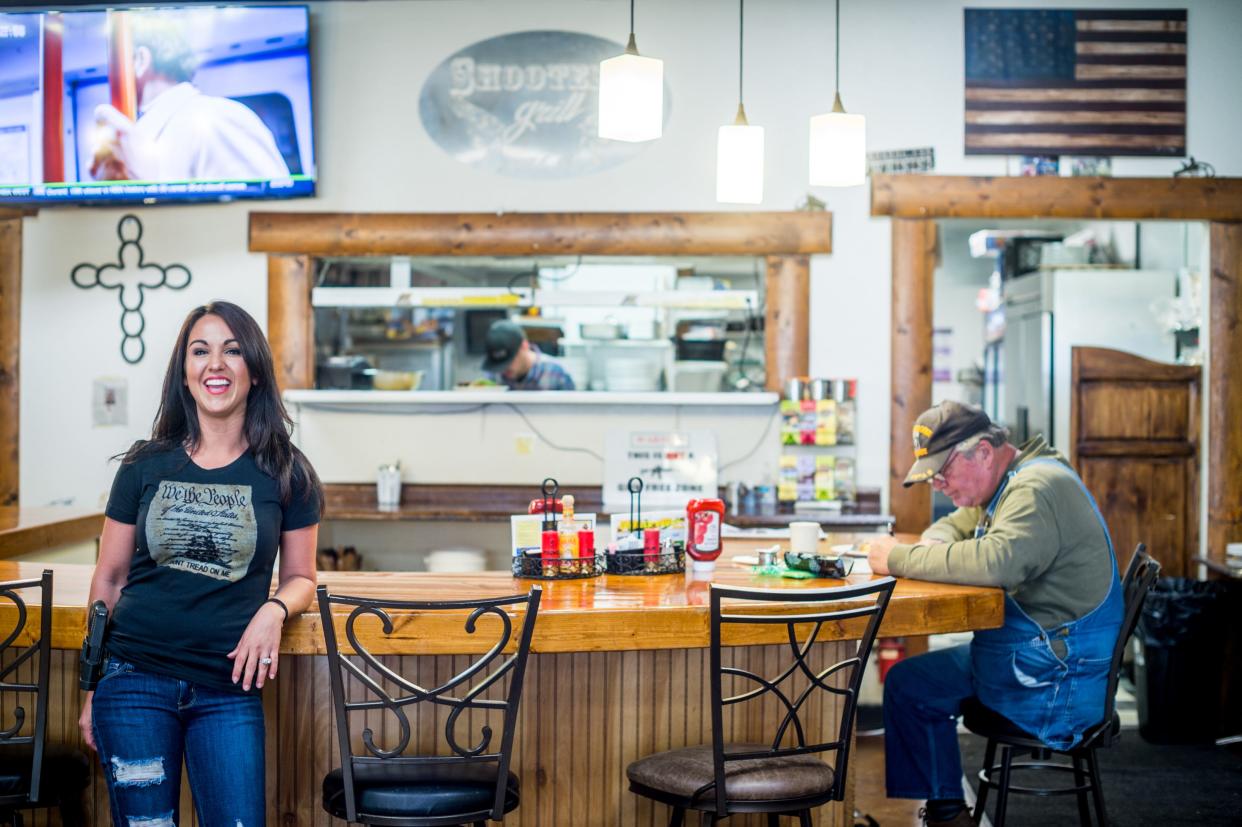 Lauren Boebert (L) stands by the counter with a dining customer inside Shooters Grill in Rifle, Colorado on April 24, 2018.