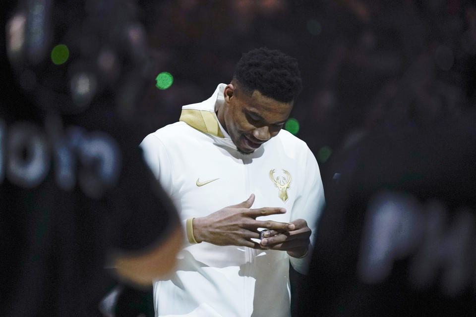 Milwaukee Bucks' Giannis Antetokounmpo looks at his championship ring before the team's NBA basketball game against the Brooklyn Nets, Tuesday, Oct. 19, 2021, in Milwaukee. (AP Photo/Morry Gash)